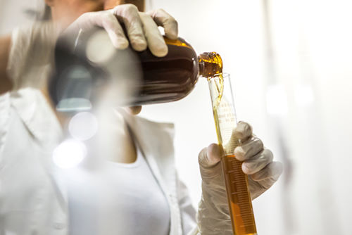 Student measuring ingredients on a cosmetic formulation training course