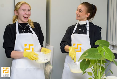 2 students laughing while formulating natural hair products