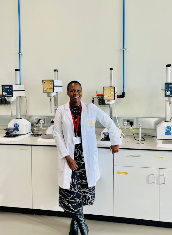 Neo Chatyoka wearing a lab coat and leaning against a cabinet in a lab.