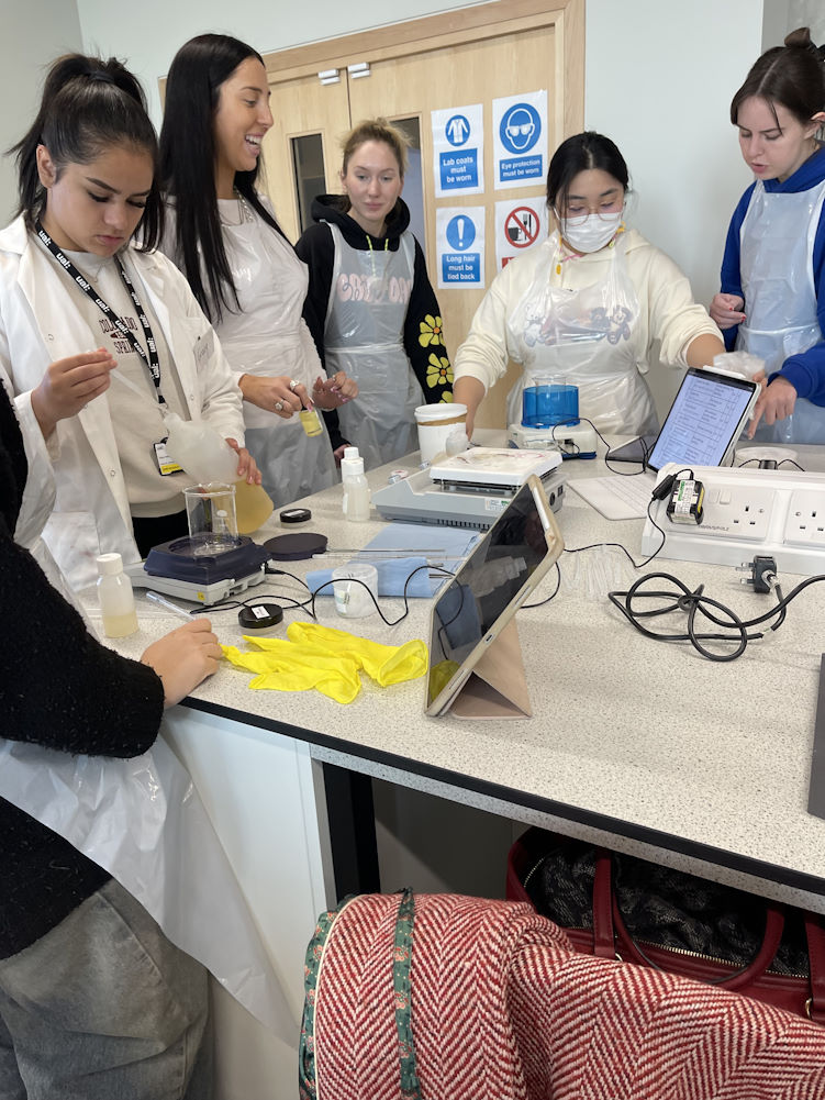 A group of students weighing ingredients while learning about how to make homemade skin care products