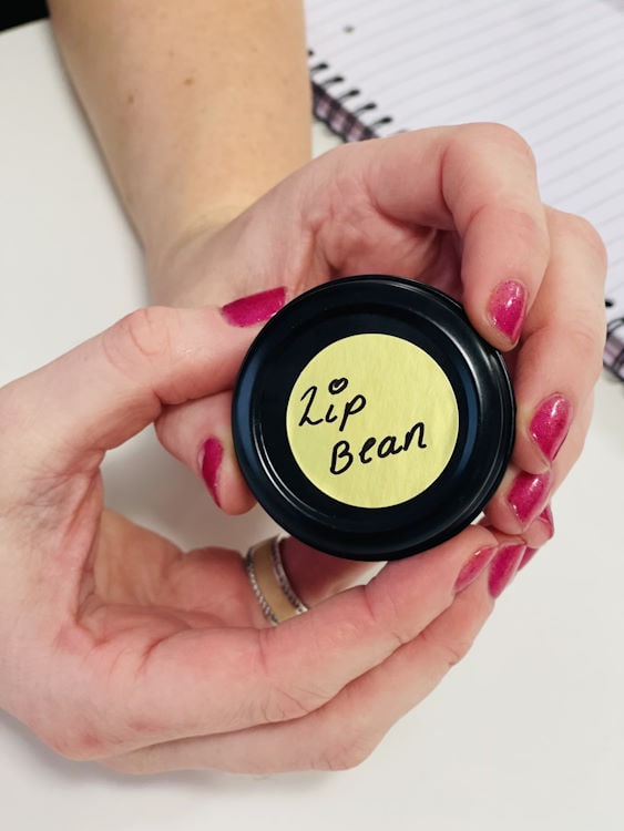 A student holding a small jar of lip bean formulated themselves